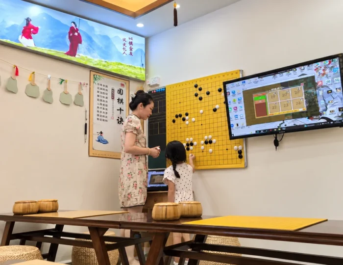 Hong Meng Academy Weiqi teacher guiding a young student during a Go lesson in Hougang, Singapore.
